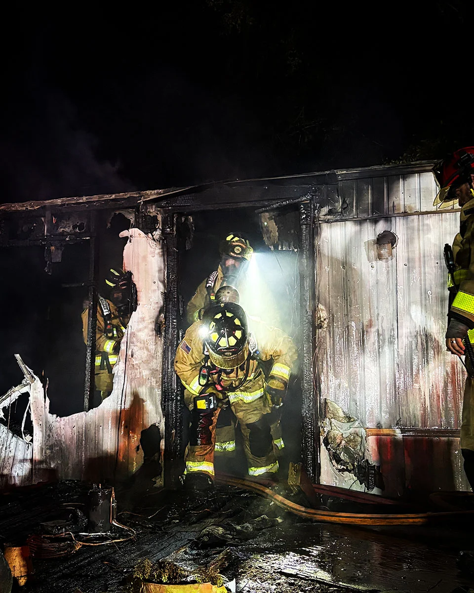 Nighttime view of the fire-damaged mobile home